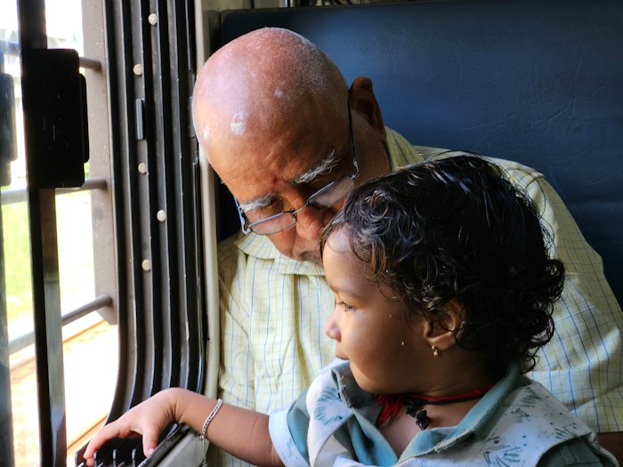 Grandfather and grandchild looking out a window