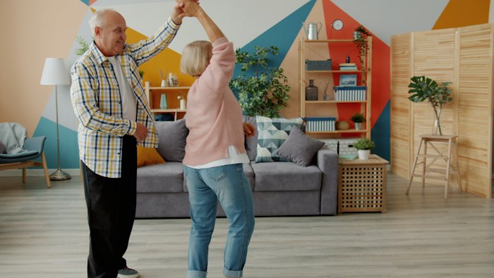 Older couple dancing together in a living room