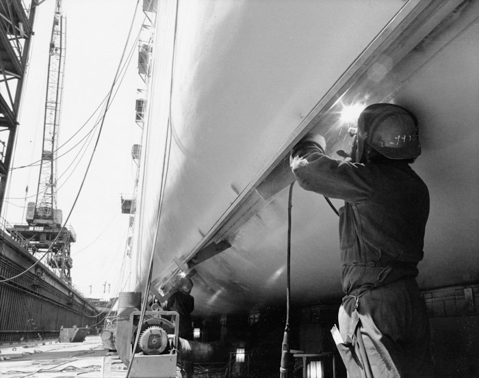 Welder working on a ship hull