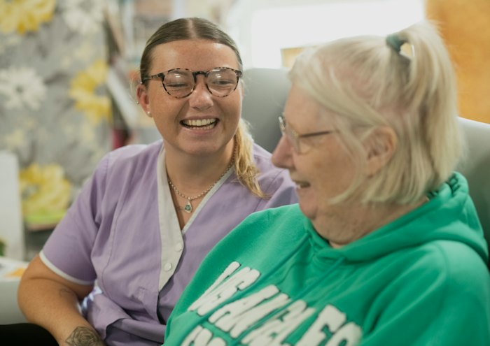 Two women laughing together indoors